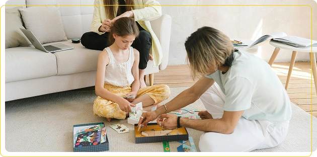 Volwassenen en een kind spelen educatieve spelletjes op het tapijt in de lichte woonkamer.
