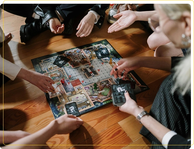 Een groep vrienden zit op de houten vloer rond het speelbord van het bordspel Cluedo, met kaarten en speelstukken.